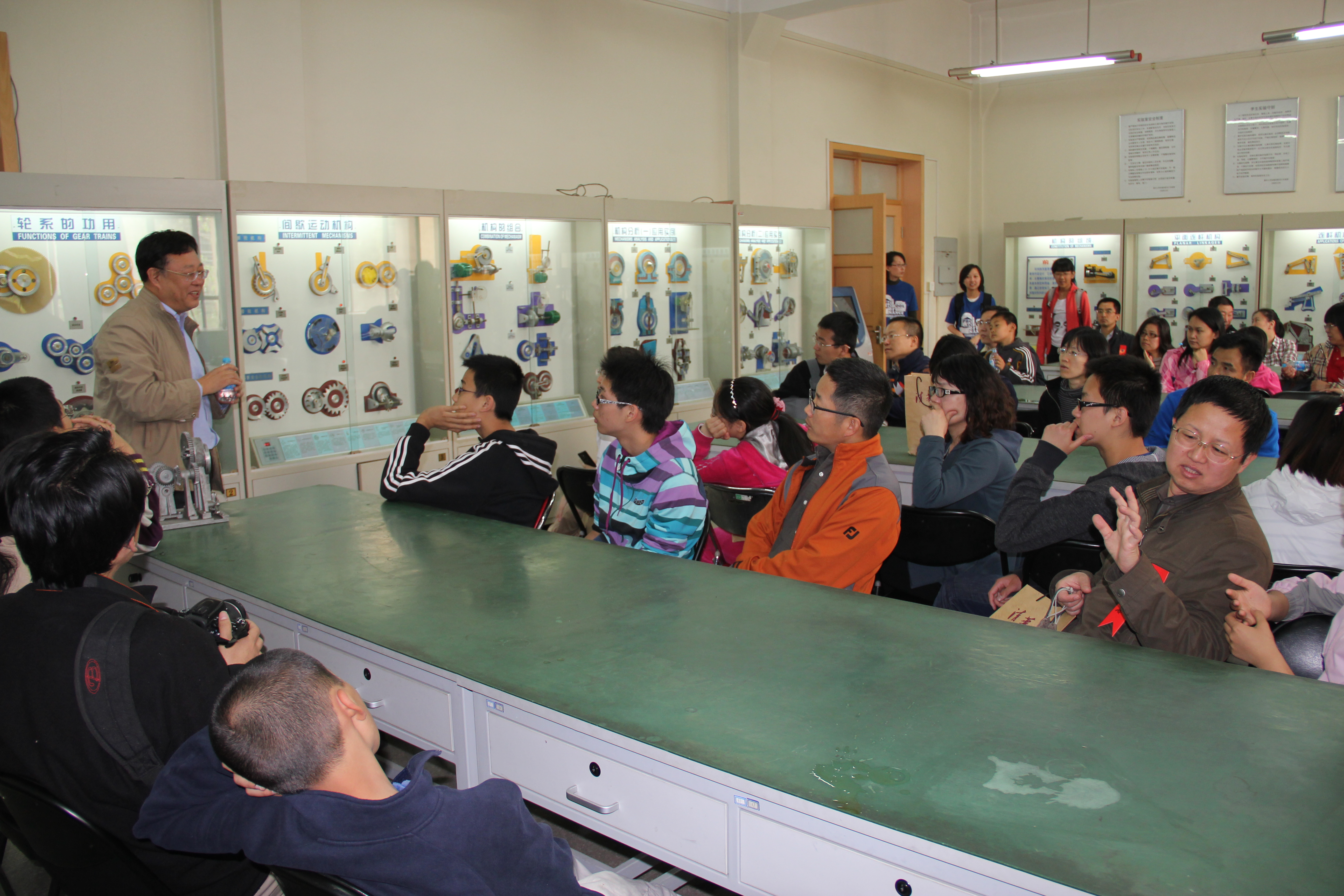 图为索双富老师向校友及子女介绍实验室情况